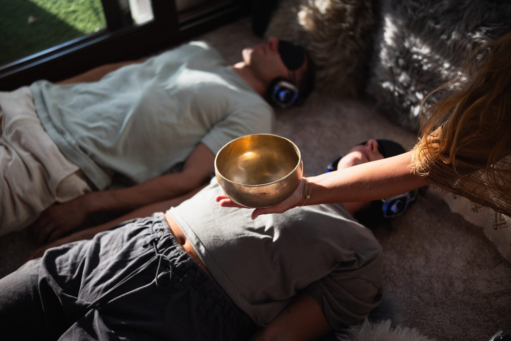People meditating with singing bowl and headphones.